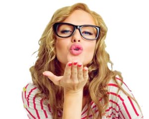 Picture of a woman named Sloane flying and blowing a kiss with a blue background